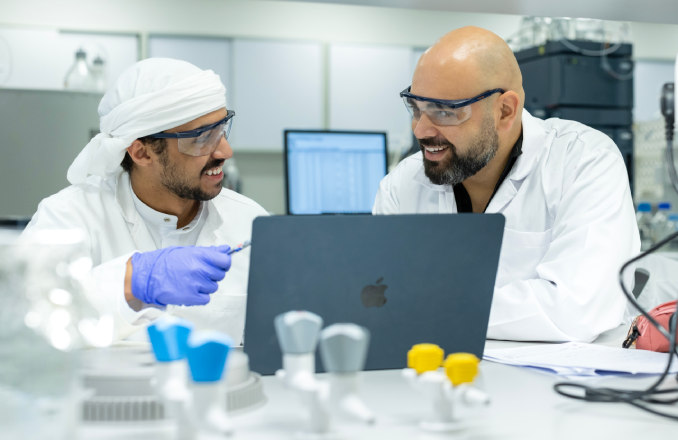 باحثان يعملان معًا في مختبر في مركز أبحاث البيئة الصحراوية بجامعة الإمارات العربية المتحدة.
