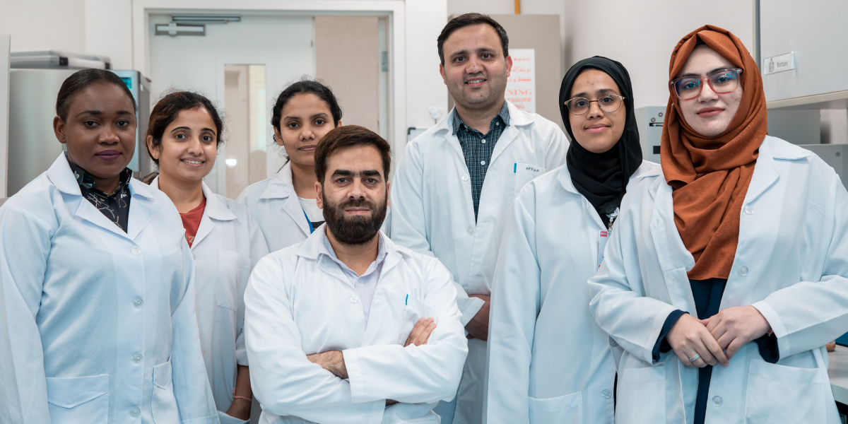 UAEU research team members in laboratory coats posing together in a laboratory.
